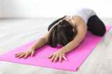 woman doing yoga pose on pink yoga mat