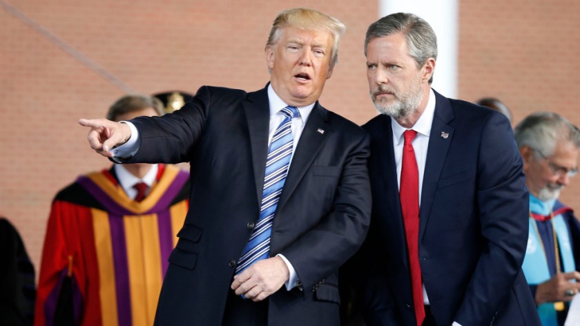 President Donald Trump gestures as he stands with Liberty University president, Jerry Falwell Jr., right, during commencement ceremonies at the school in Lynchburg, Va., Saturday, May 13, 2017. (AP Photo/Steve Helber)