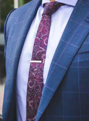 person in blue suit and red paisley necktie